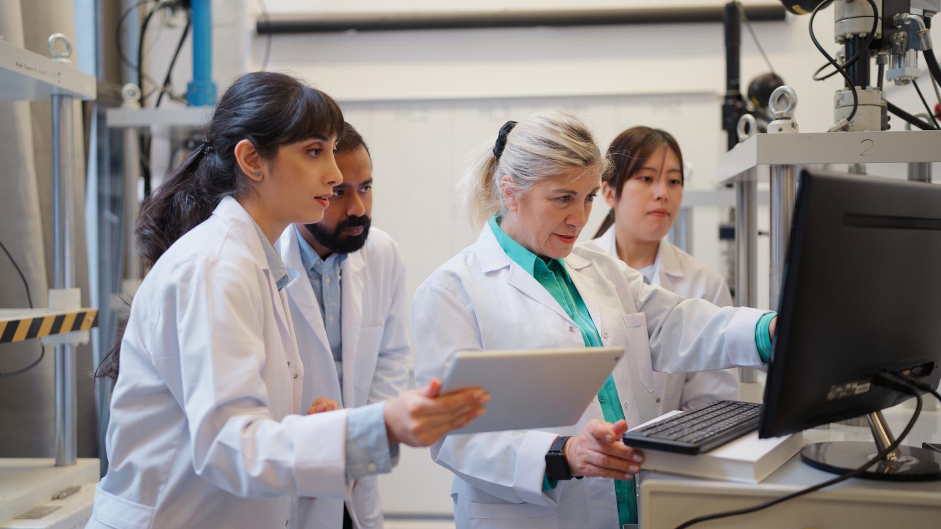 Multi-racial group of scientists researching and teamworking in laboratory