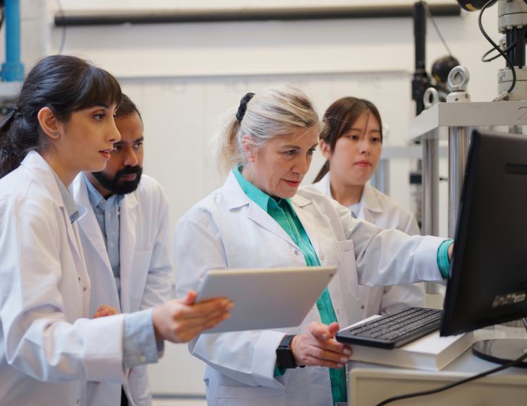 Multi-racial group of scientists researching and teamworking in laboratory