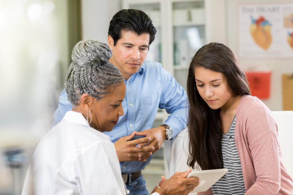 Doctor reviews teenage patient’s test results