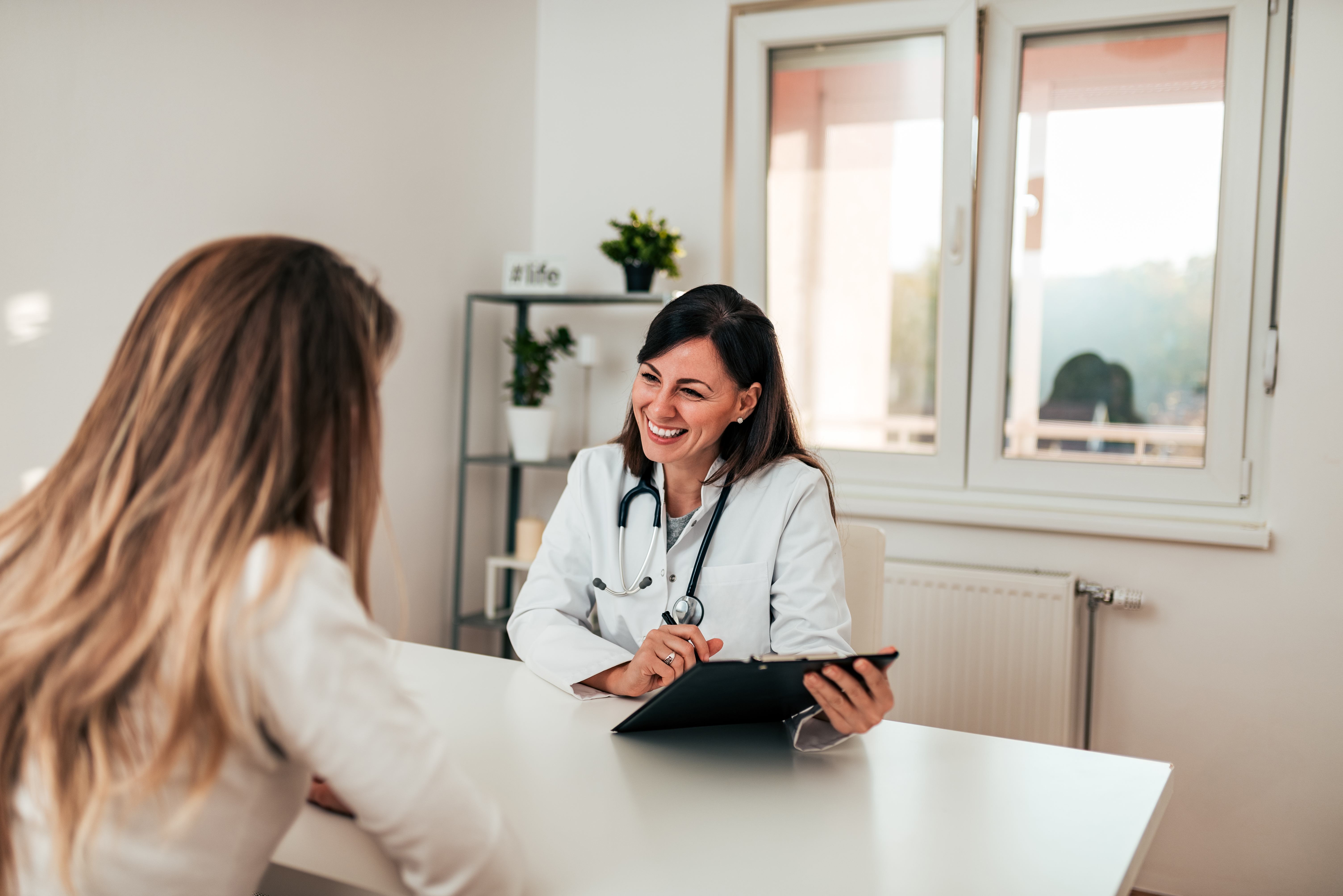 Beautiful female specialist talking to her patient.