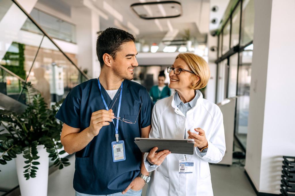 Senior female doctor talking to her young colleague in the hospital corridor