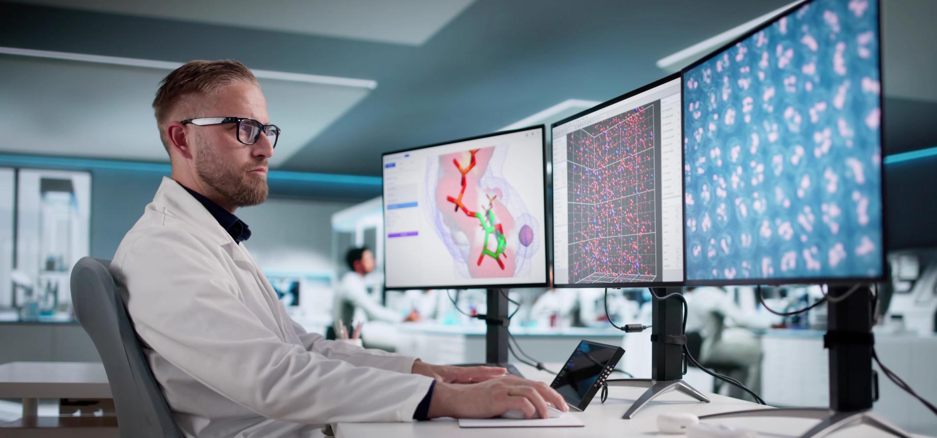 Young Scientist Analyzes Data On Multiple Screens In Busy Laboratory