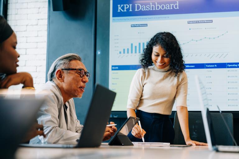 Young businesswoman presenting KPI dashboard during team meeting