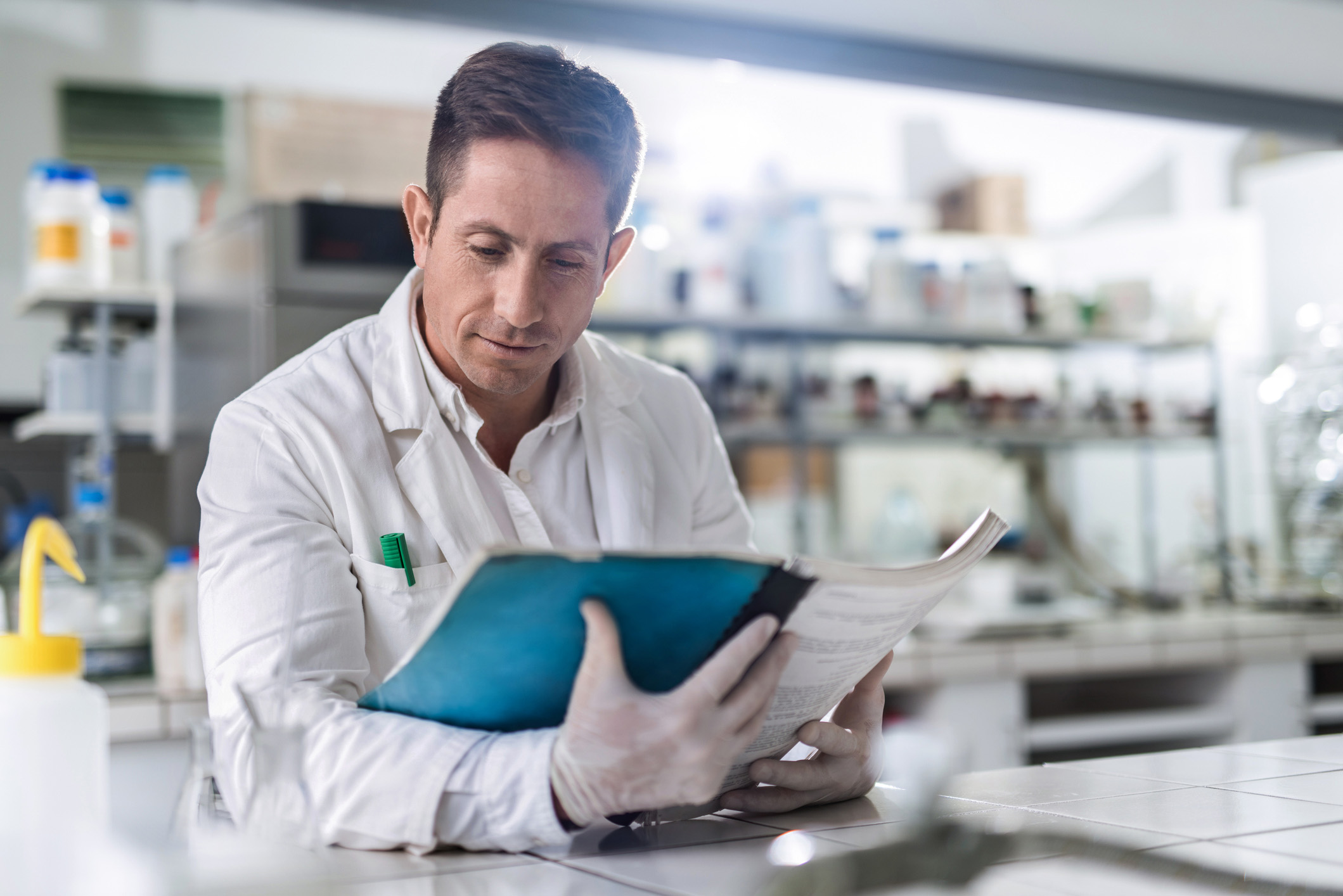Male chemist reading medical data in laboratory.